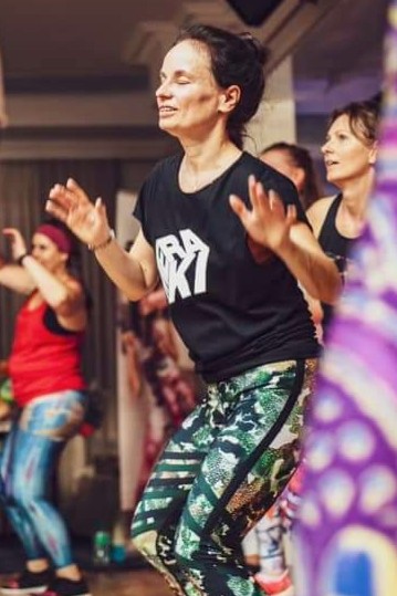 Tańcząca kobieta ubrana w leginsy z motywem moro i w czarnej koszulce - Przedszkole Samorządowe Nr 2 Pod Słonkiem w Białymstoku