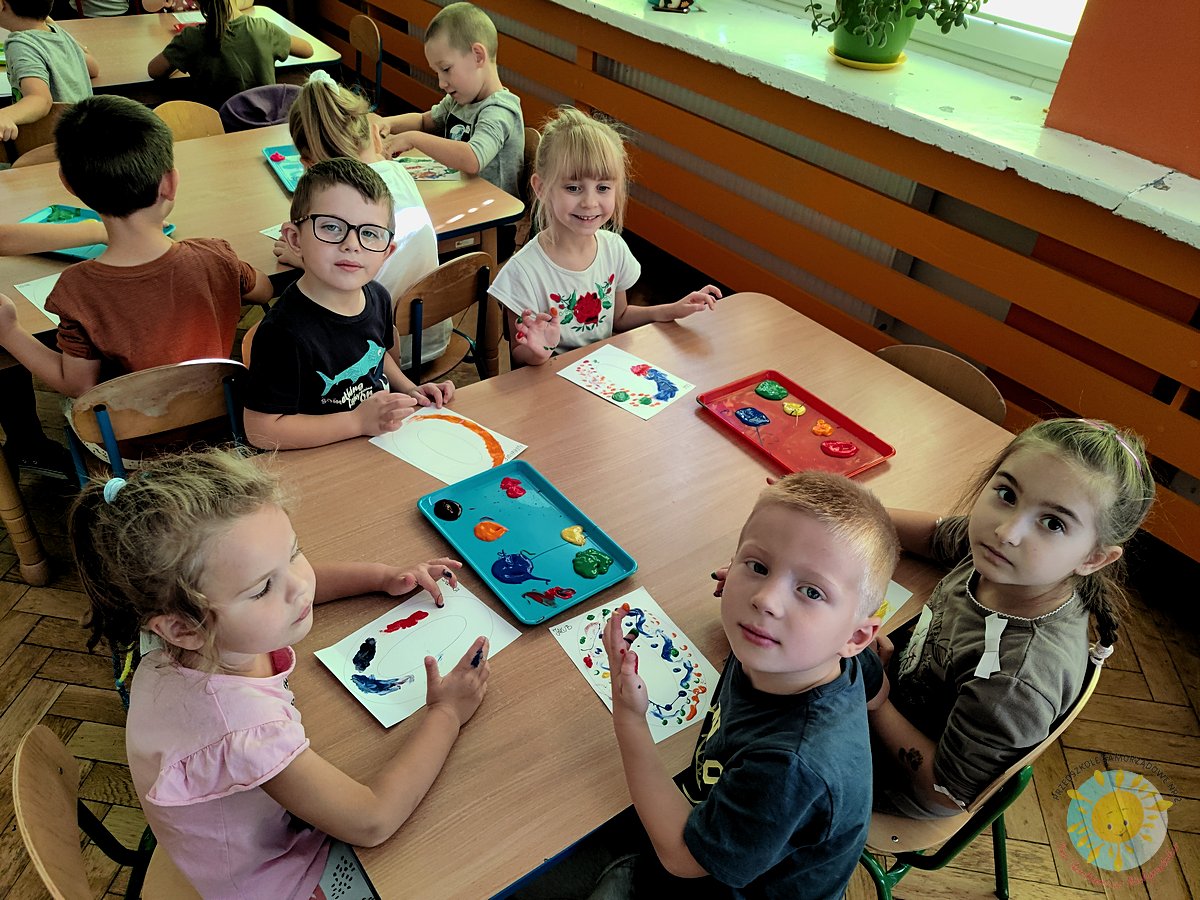 Dzieci uśmiechają się, pracując przy stole - Przedszkole Samorządowe Nr 2 Pod Słonkiem w Białymstoku