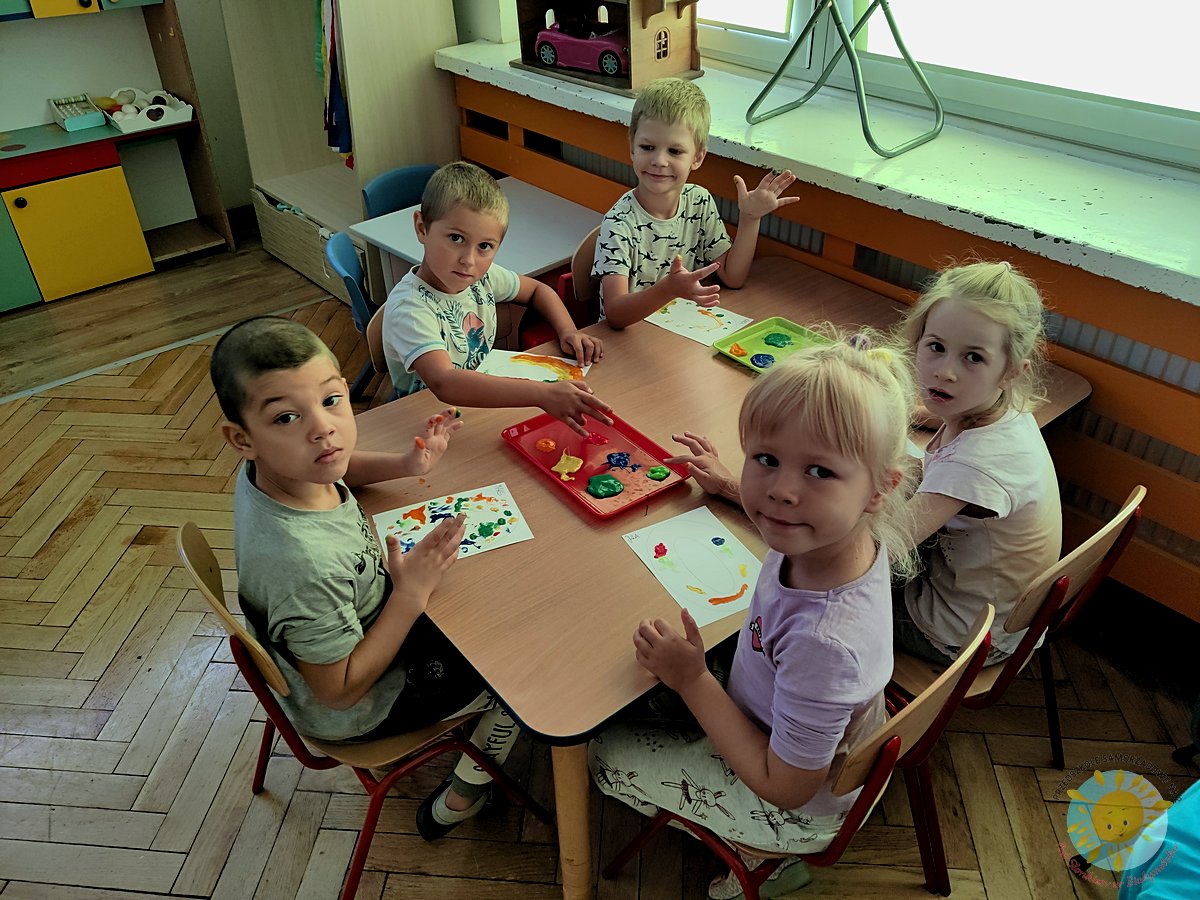 Dzieci uśmiechają się, pracując przy stole - Przedszkole Samorządowe Nr 2 Pod Słonkiem w Białymstoku