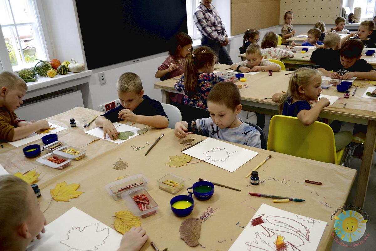 Dzieci siedzą przy stole i malują liście - Przedszkole Samorządowe Nr 2 Pod Słonkiem w Białymstoku