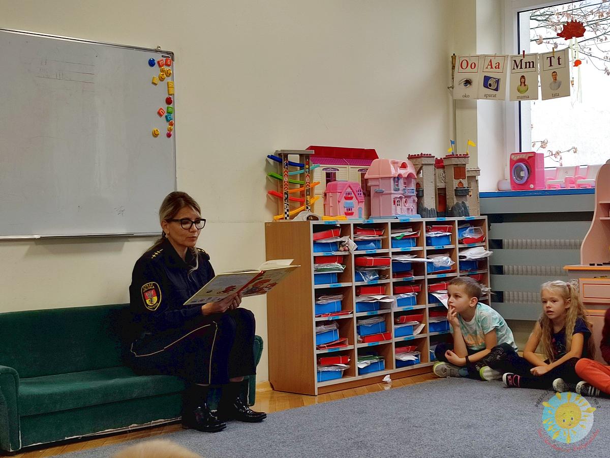 Dzieci siedzą na dywanie a pani ze Straży Miejskiej uczy ich udzielania pierwszej pomocy - Przedszkole Samorządowe Nr 2 Pod Słonkiem w Białymstoku