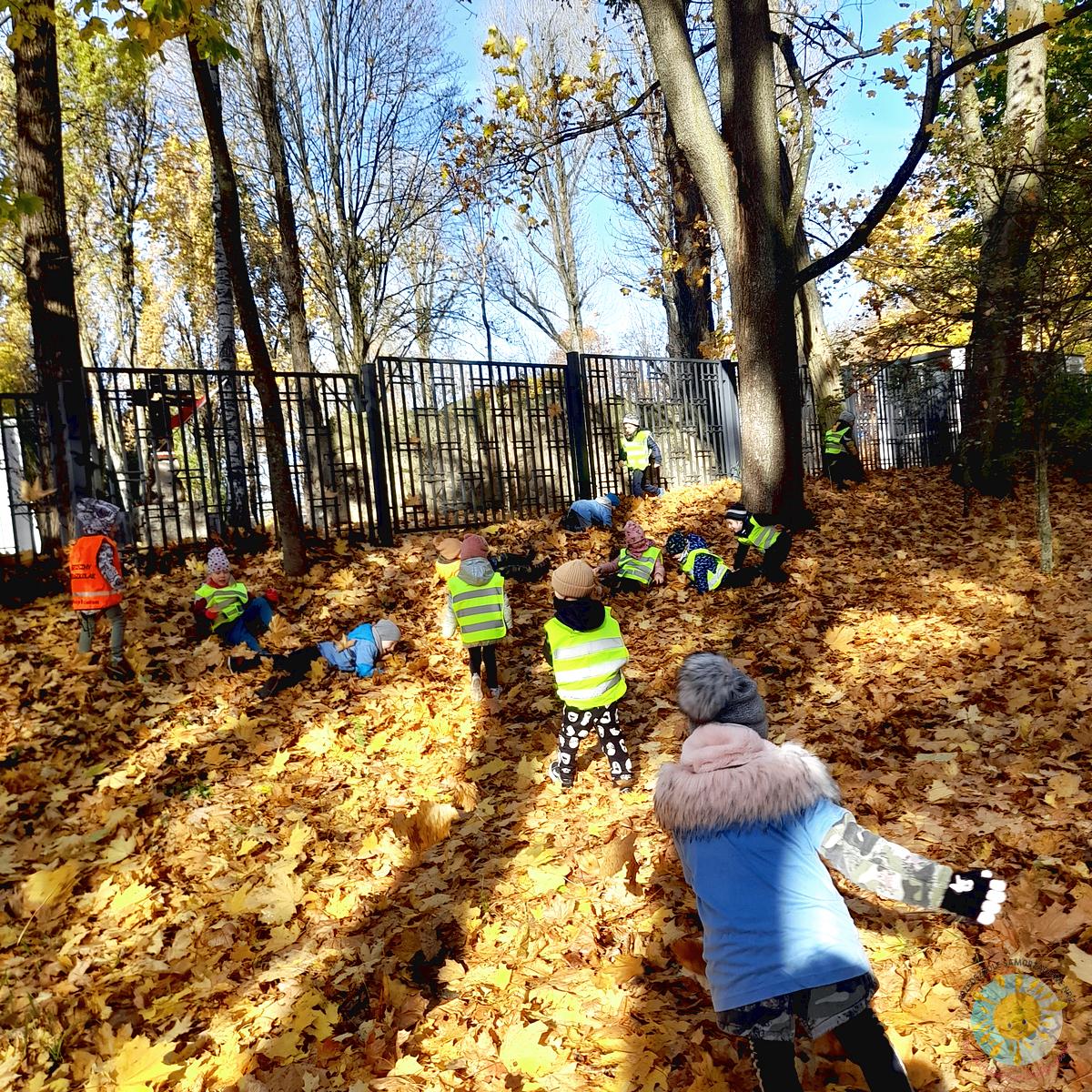 Dzieci staczają się z górki pełnej liści - Przedszkole Samorządowe Nr 2 Pod Słonkiem w Białymstoku