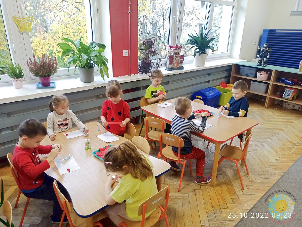 Dzieci pracują przy stole, tworząc jesienny obrazek wiewiórki z liści - Przedszkole Samorządowe Nr 2 Pod Słonkiem w Białymstoku