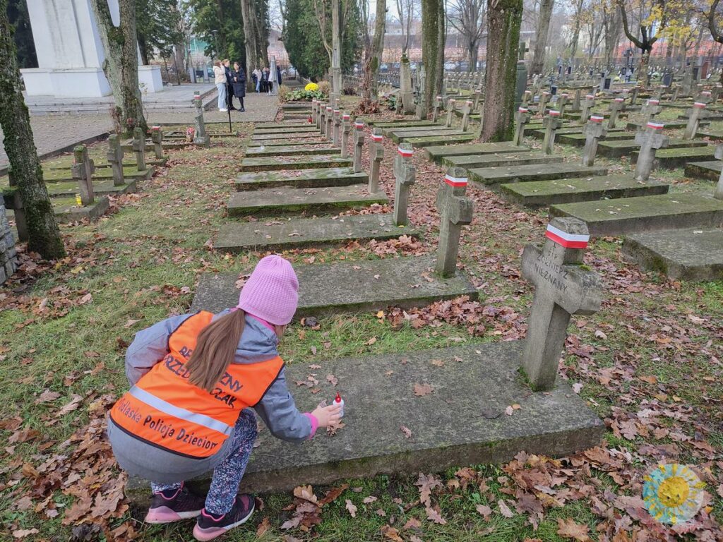 Dzieci stawiają znicze na grobach cmentarza wojskowego - Przedszkole Samorządowe Nr 2 Pod Słonkiem w Białymstoku