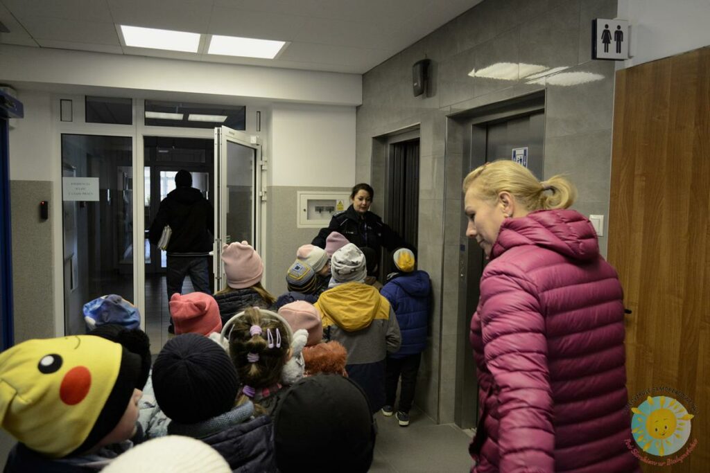 Dzieci wraz z panią przemieszają się do windy w budynku policji - Przedszkole Samorządowe Nr 2 Pod Słonkiem w Białymstoku