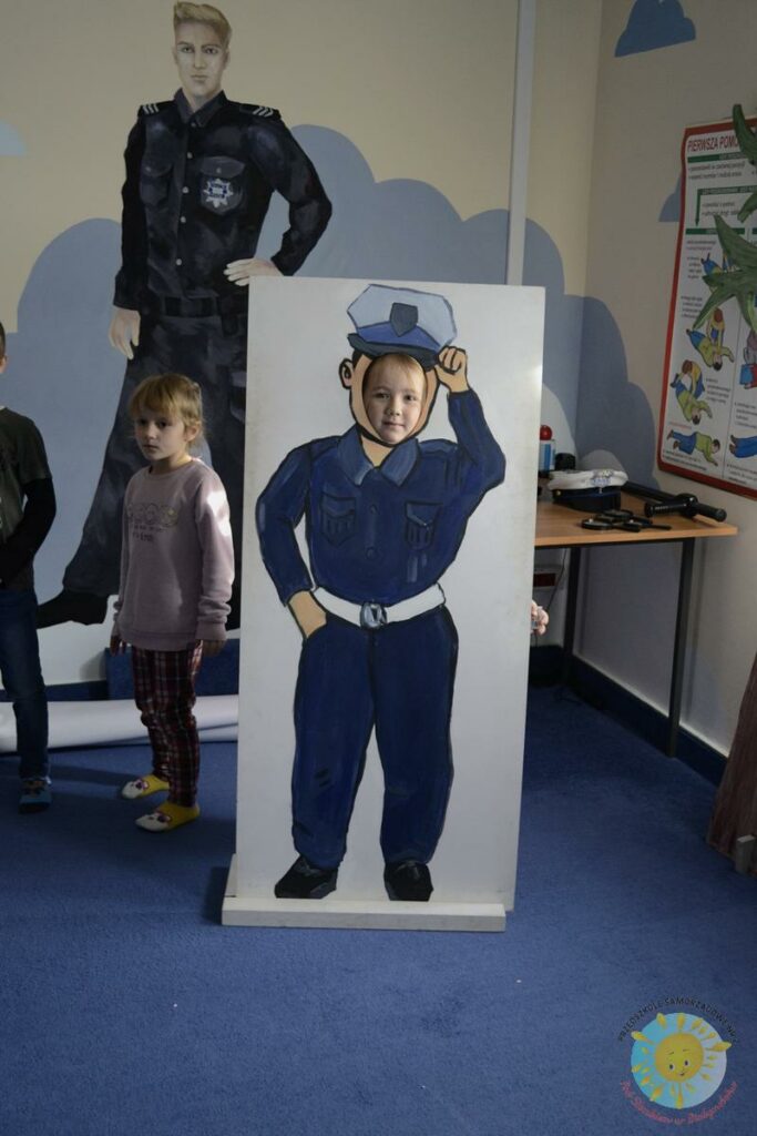 Dziecko pozuje do zdjęcia w figurze policjanta wykonanej w kartonu - Przedszkole Samorządowe Nr 2 Pod Słonkiem w Białymstoku