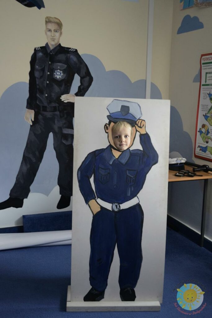 Dziecko pozuje do zdjęcia w figurze policjanta wykonanej w kartonu - Przedszkole Samorządowe Nr 2 Pod Słonkiem w Białymstoku