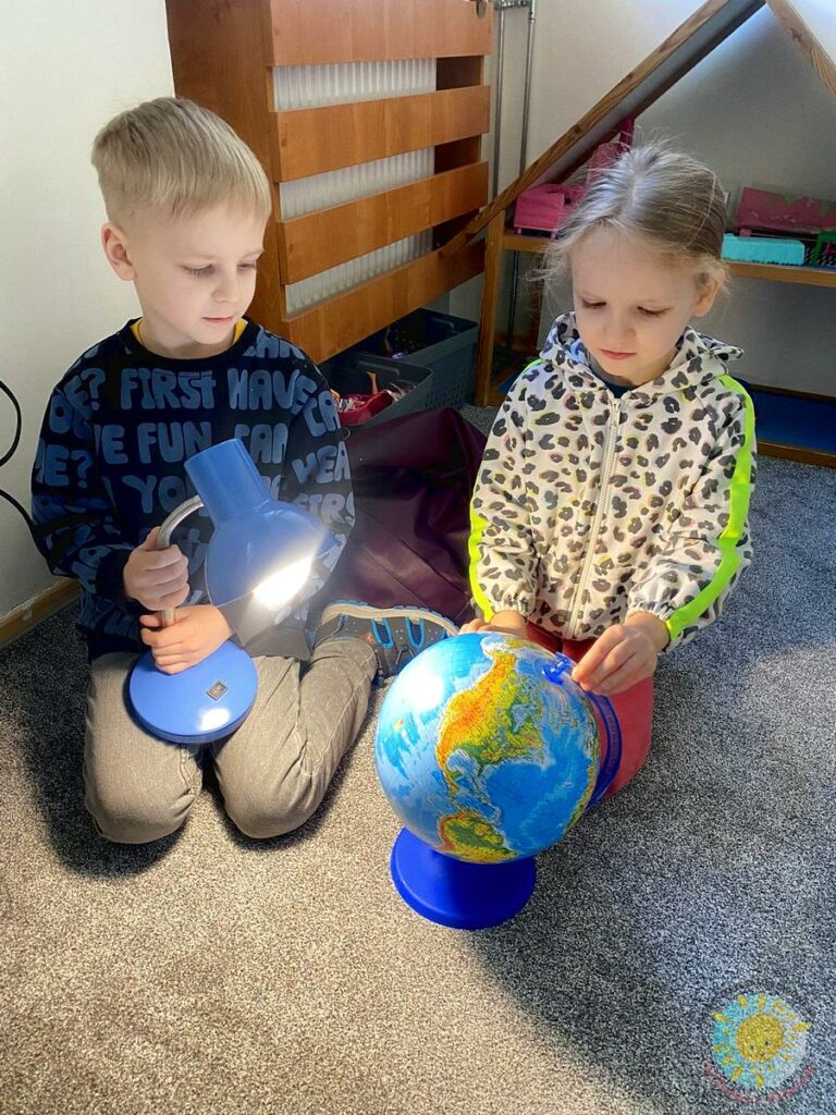 Dzieci bawią się globusem i lampką - Przedszkole Samorządowe Nr 2 Pod Słonkiem w Białymstoku