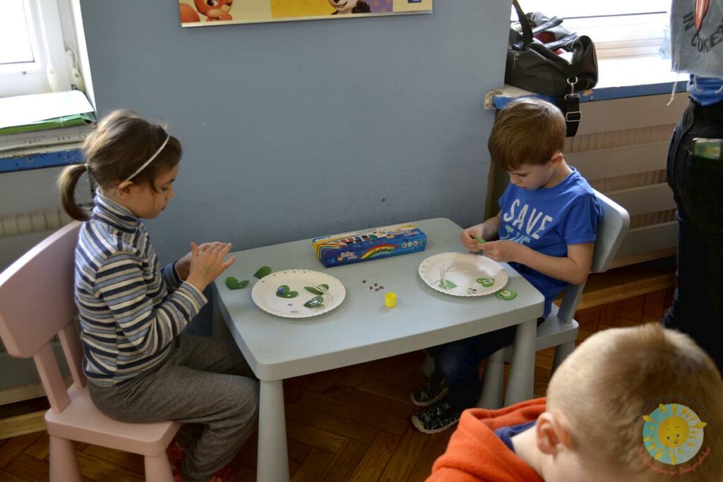 Dzieci siedzą przy stole i biorą udział w zajęciach o ekologii - Przedszkole Samorządowe Nr 2 Pod Słonkiem w Białymstoku
