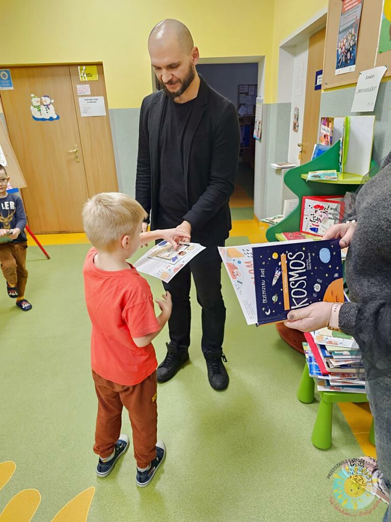 Dziecko wieku przedszkolnym odbiera nagrodę w postaci książki od dyrektora przedszkola - Przedszkole Samorządowe Nr 2 Pod Słonkiem w Białymstoku