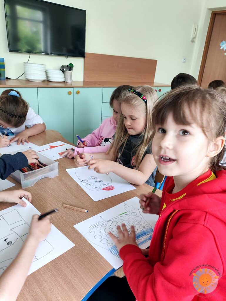 Siedzące dzieci przy przedszkolnym stoliku, wykonują pracę - Przedszkole Samorządowe Nr 2 Pod Słonkiem w Białymstoku