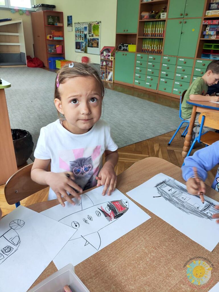 Siedzące dzieci przy przedszkolnym stoliku, wykonują pracę - Przedszkole Samorządowe Nr 2 Pod Słonkiem w Białymstoku
