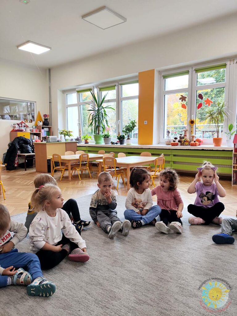 Siedzące dzieci na dywanie, które biorą udział w zajęciach - Przedszkole Samorządowe Nr 2 Pod Słonkiem w Białymstoku