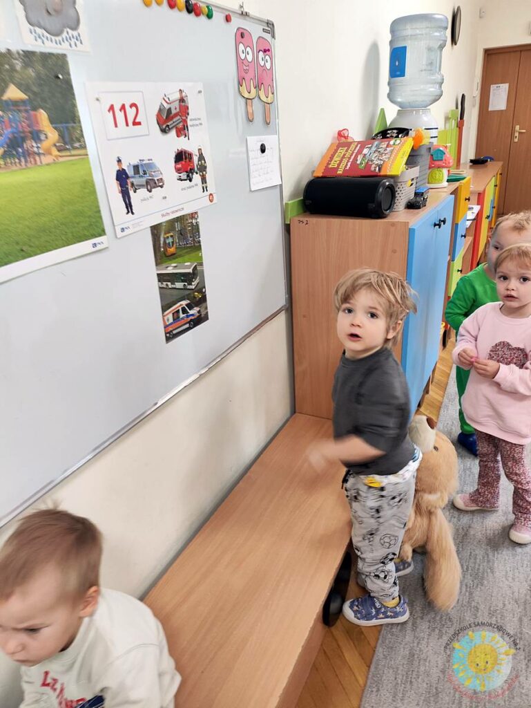 Stojące dziecko przy tablicy, wieszające obrazek - Przedszkole Samorządowe Nr 2 Pod Słonkiem w Białymstoku