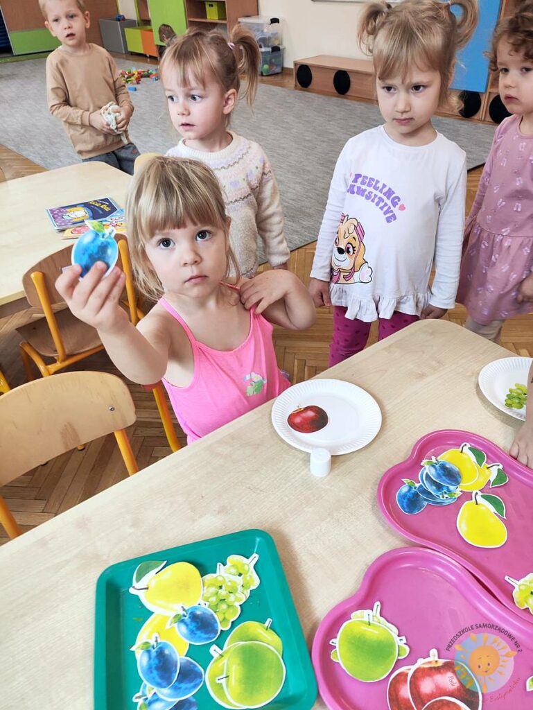 Siedzące dzieci przy stole i wykonują pracę plastyczną - Przedszkole Samorządowe Nr 2 Pod Słonkiem w Białymstoku