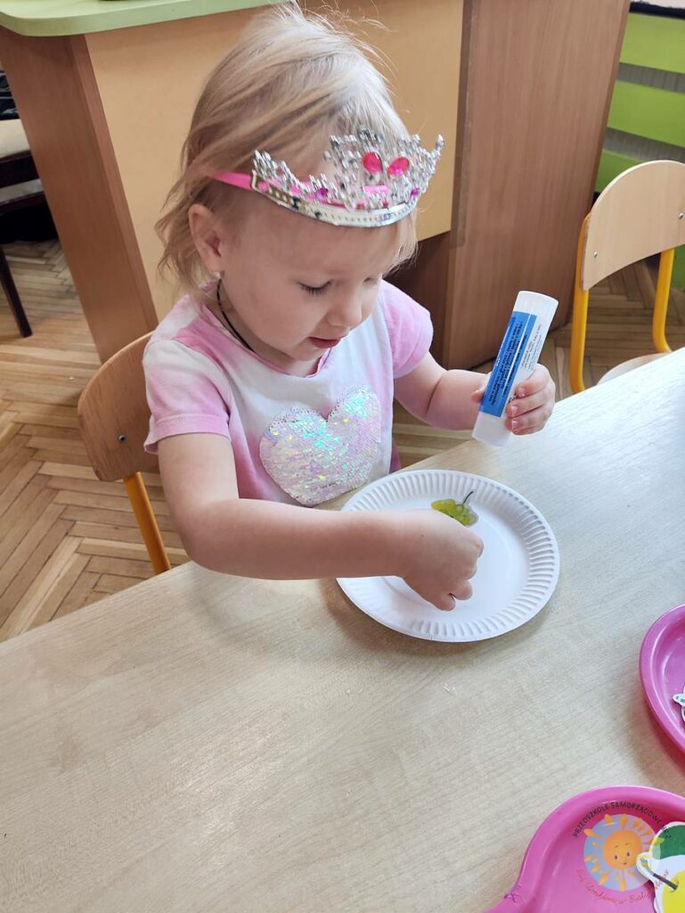 Siedzące dzieci przy stole i wykonują pracę plastyczną - Przedszkole Samorządowe Nr 2 Pod Słonkiem w Białymstoku