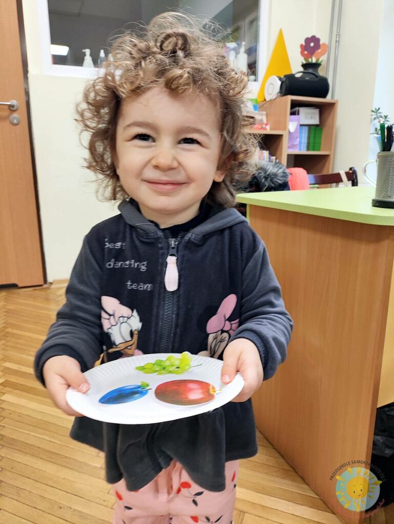 Siedzące dzieci przy stole i wykonują pracę plastyczną - Przedszkole Samorządowe Nr 2 Pod Słonkiem w Białymstoku