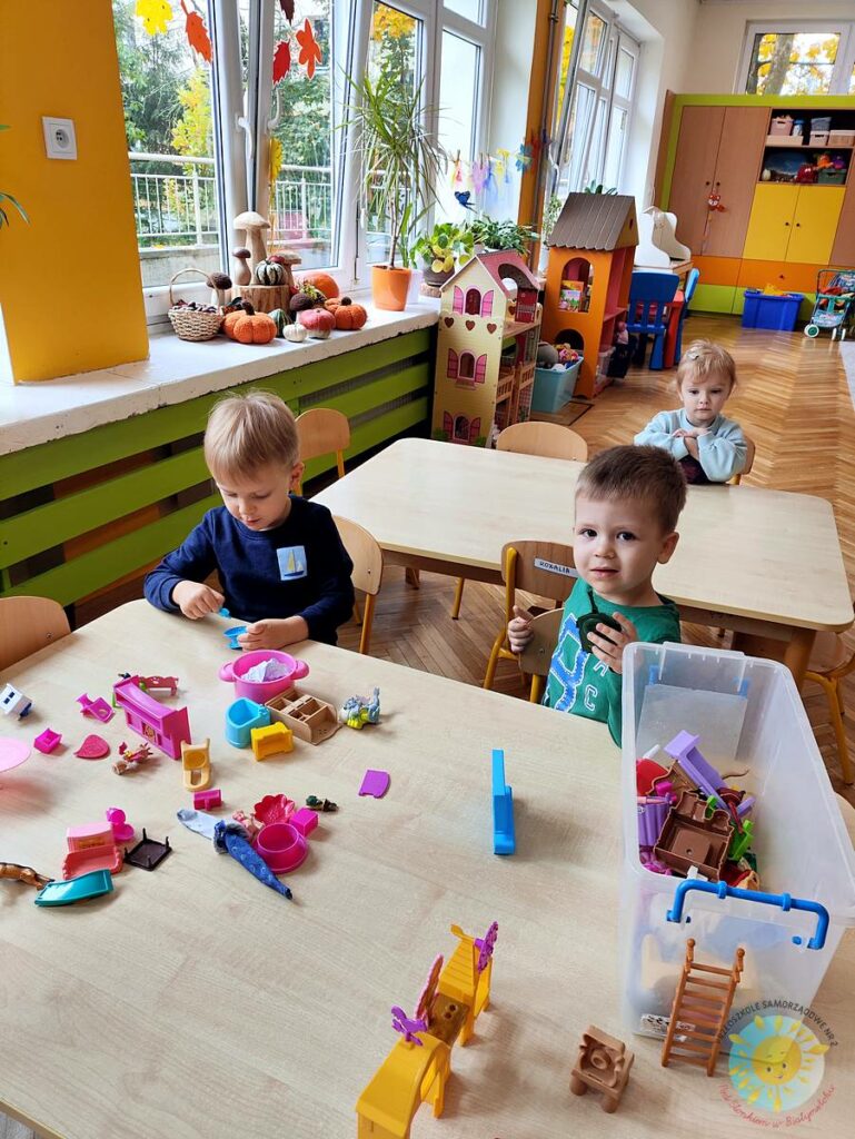 Siedzące dzieci przy stole i wykonują pracę plastyczną - Przedszkole Samorządowe Nr 2 Pod Słonkiem w Białymstoku