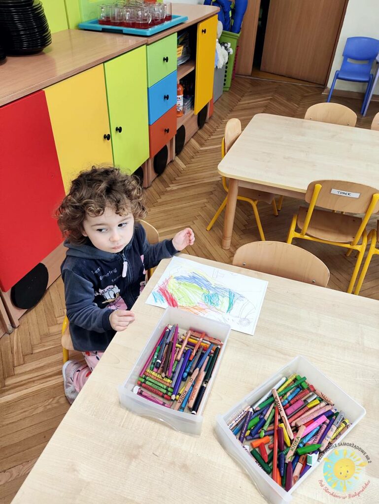 Siedzące dzieci przy stole i wykonują pracę plastyczną - Przedszkole Samorządowe Nr 2 Pod Słonkiem w Białymstoku