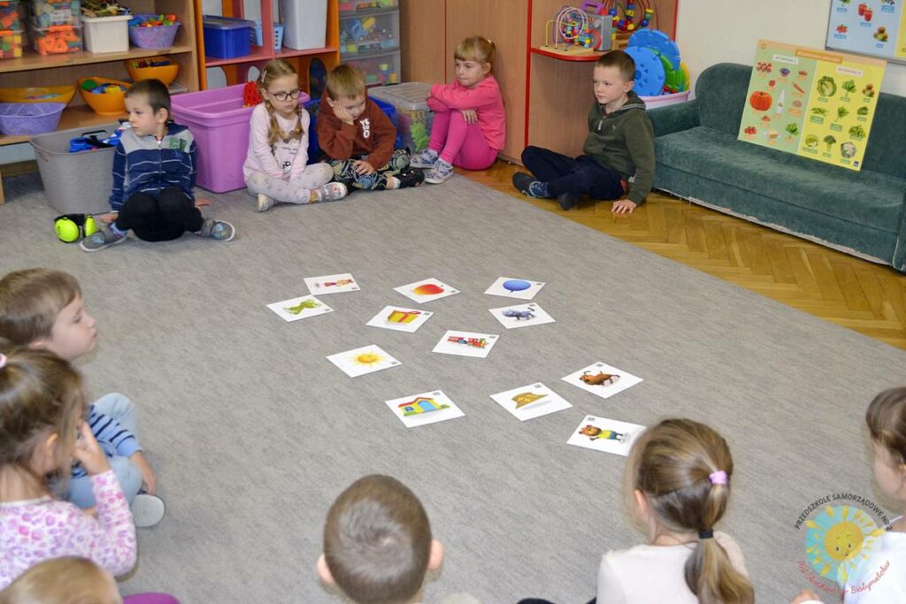 Siedzące dzieci na dywanie, które biorą udział w zajęciach - Przedszkole Samorządowe Nr 2 Pod Słonkiem w Białymstoku