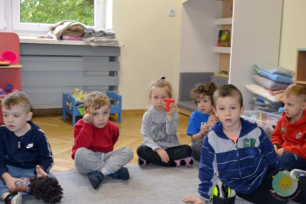 Siedzące dzieci na dywanie, które biorą udział w zajęciach - Przedszkole Samorządowe Nr 2 Pod Słonkiem w Białymstoku