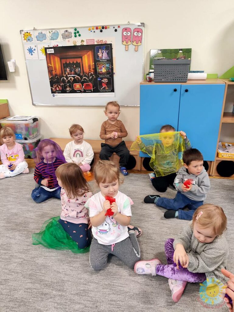 Siedzące dzieci na dywanie, które biorą udział w zajęciach - Przedszkole Samorządowe Nr 2 Pod Słonkiem w Białymstoku