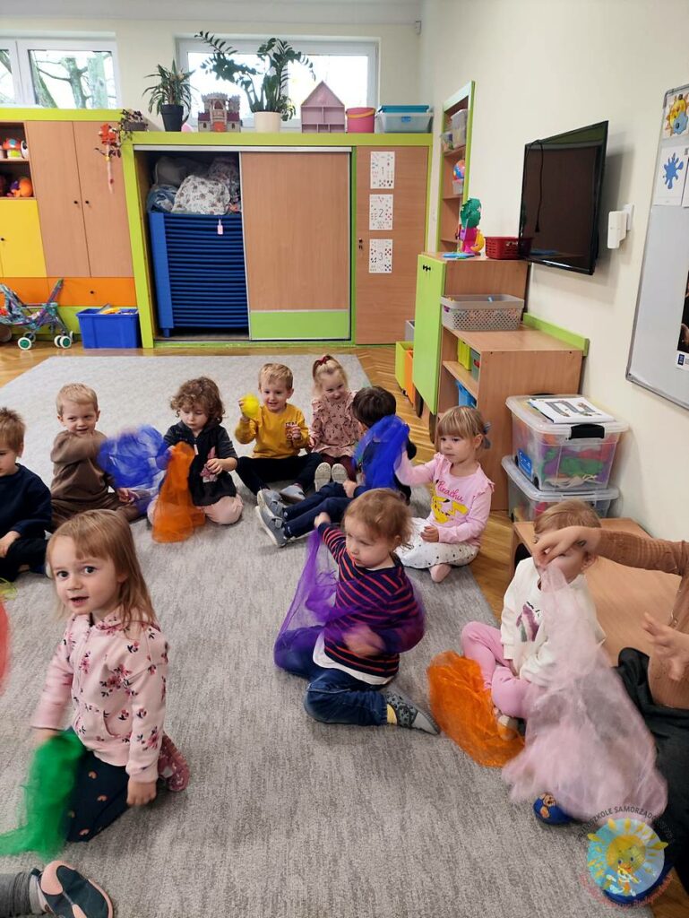 Siedzące dzieci na dywanie, które biorą udział w zajęciach - Przedszkole Samorządowe Nr 2 Pod Słonkiem w Białymstoku