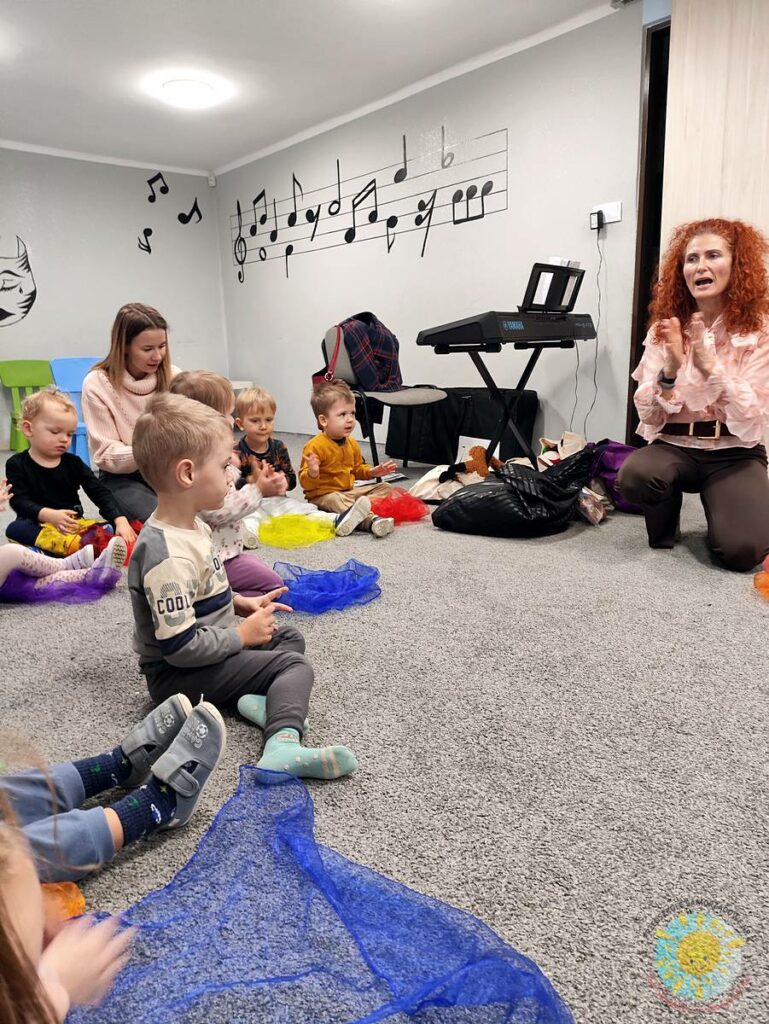 Siedzące dzieci na dywanie, które biorą udział w zajęciach - Przedszkole Samorządowe Nr 2 Pod Słonkiem w Białymstoku