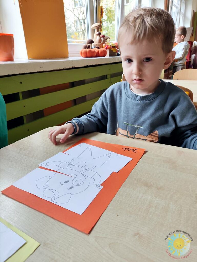 Siedzące dzieci przy przedszkolnym stoliku, wykonują pracę - Przedszkole Samorządowe Nr 2 Pod Słonkiem w Białymstoku