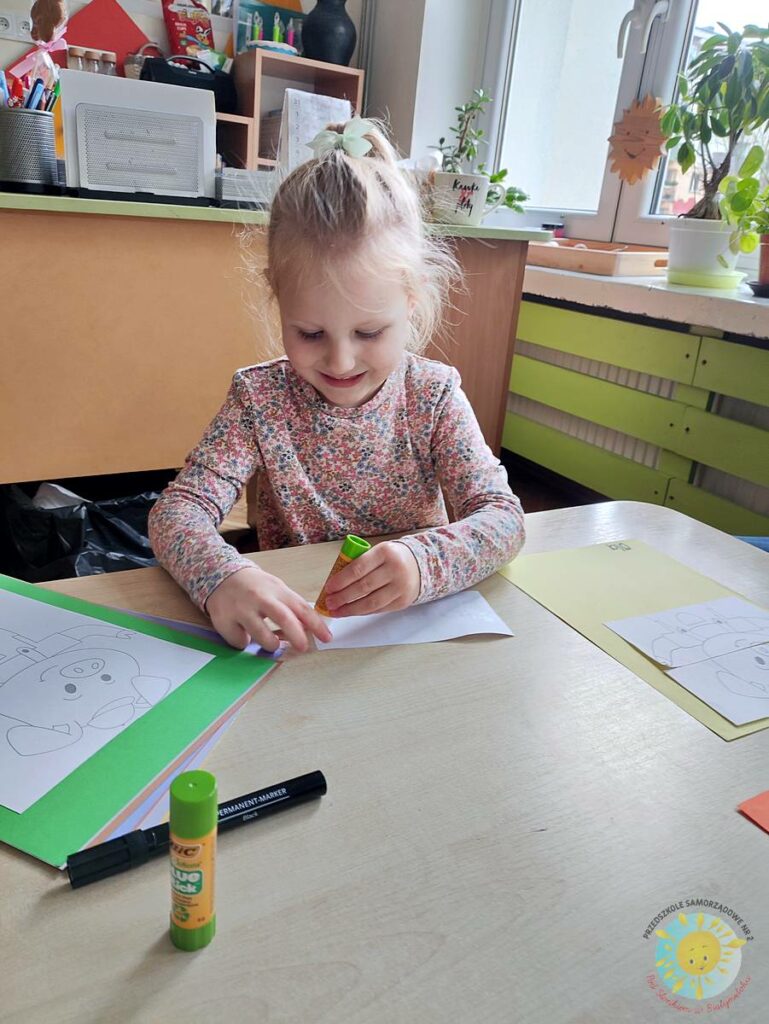 Siedzące dzieci przy przedszkolnym stoliku, wykonują pracę - Przedszkole Samorządowe Nr 2 Pod Słonkiem w Białymstoku