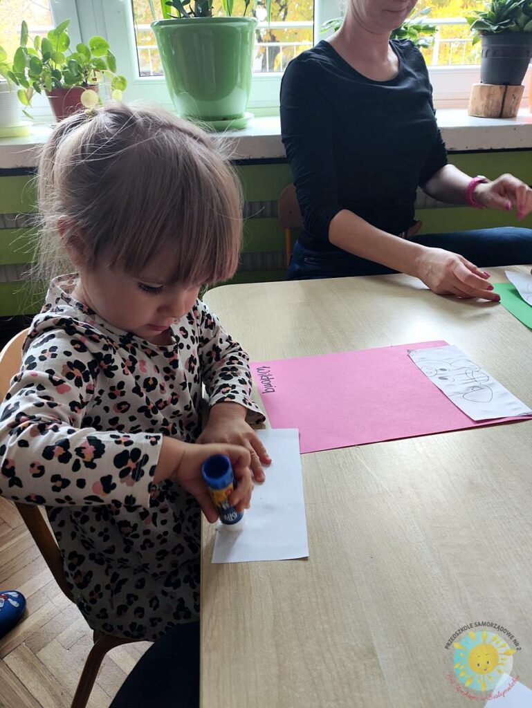 Siedzące dzieci przy przedszkolnym stoliku, wykonują pracę - Przedszkole Samorządowe Nr 2 Pod Słonkiem w Białymstoku