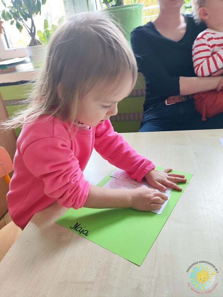 Siedzące dzieci przy przedszkolnym stoliku, wykonują pracę - Przedszkole Samorządowe Nr 2 Pod Słonkiem w Białymstoku