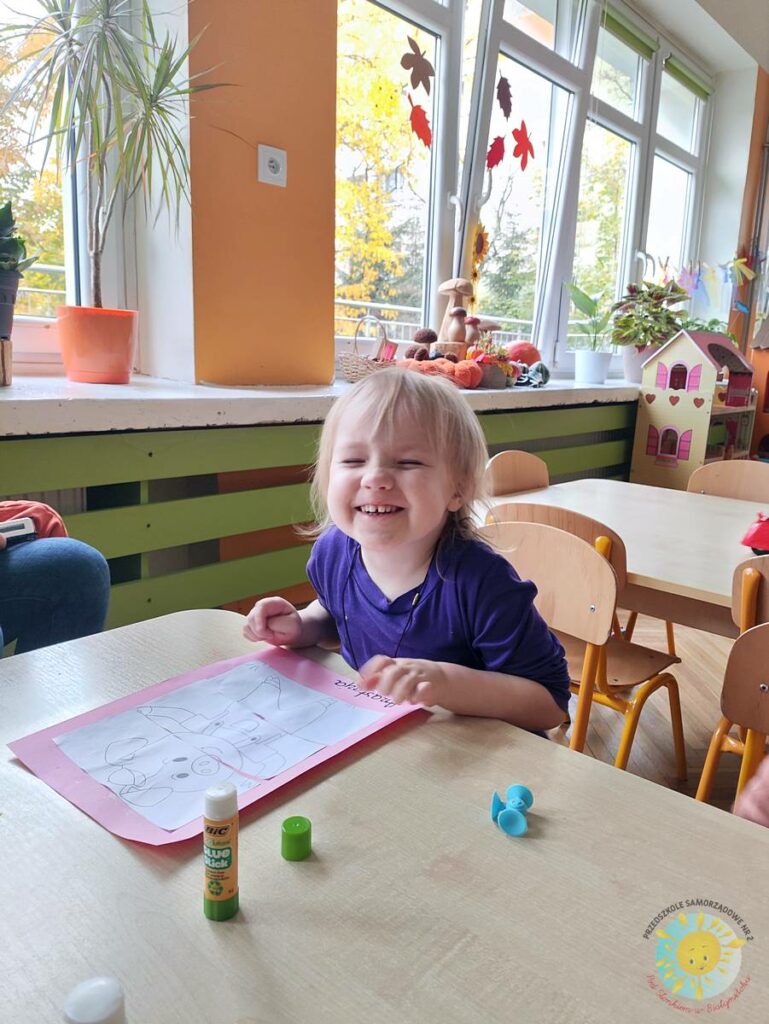 Siedzące dzieci przy przedszkolnym stoliku, wykonują pracę - Przedszkole Samorządowe Nr 2 Pod Słonkiem w Białymstoku