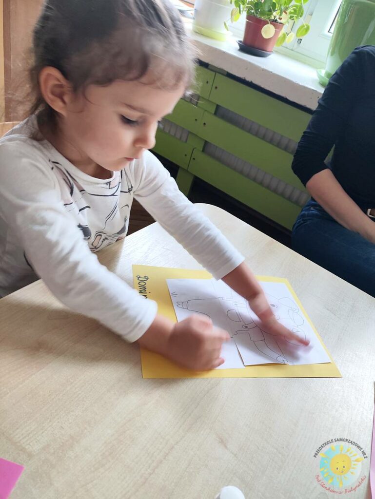 Siedzące dzieci przy przedszkolnym stoliku, wykonują pracę - Przedszkole Samorządowe Nr 2 Pod Słonkiem w Białymstoku