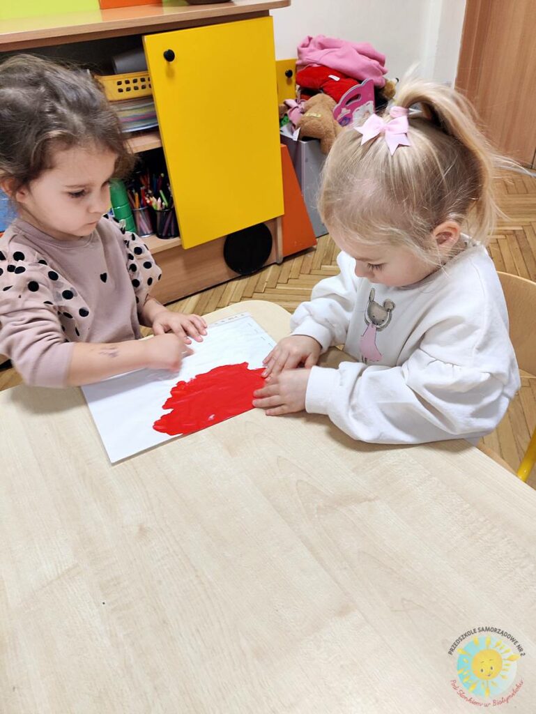 Siedzące dzieci przy stole i wykonują pracę plastyczną - Przedszkole Samorządowe Nr 2 Pod Słonkiem w Białymstoku