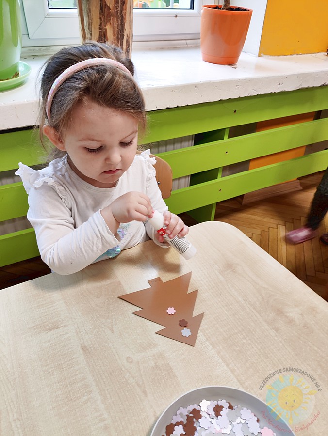 Siedzące dzieci przy stole i wykonują pracę plastyczną - Przedszkole Samorządowe Nr 2 Pod Słonkiem w Białymstoku