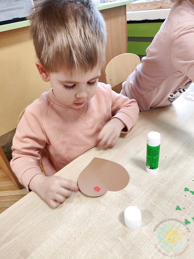 Siedzące dzieci przy stole i wykonują pracę plastyczną - Przedszkole Samorządowe Nr 2 Pod Słonkiem w Białymstoku