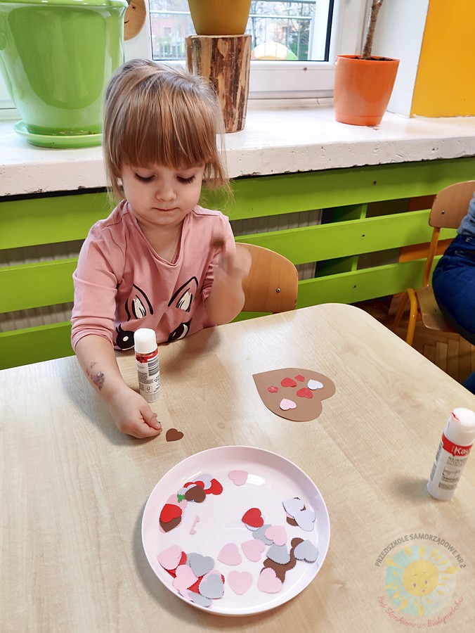 Siedzące dzieci przy stole i wykonują pracę plastyczną - Przedszkole Samorządowe Nr 2 Pod Słonkiem w Białymstoku