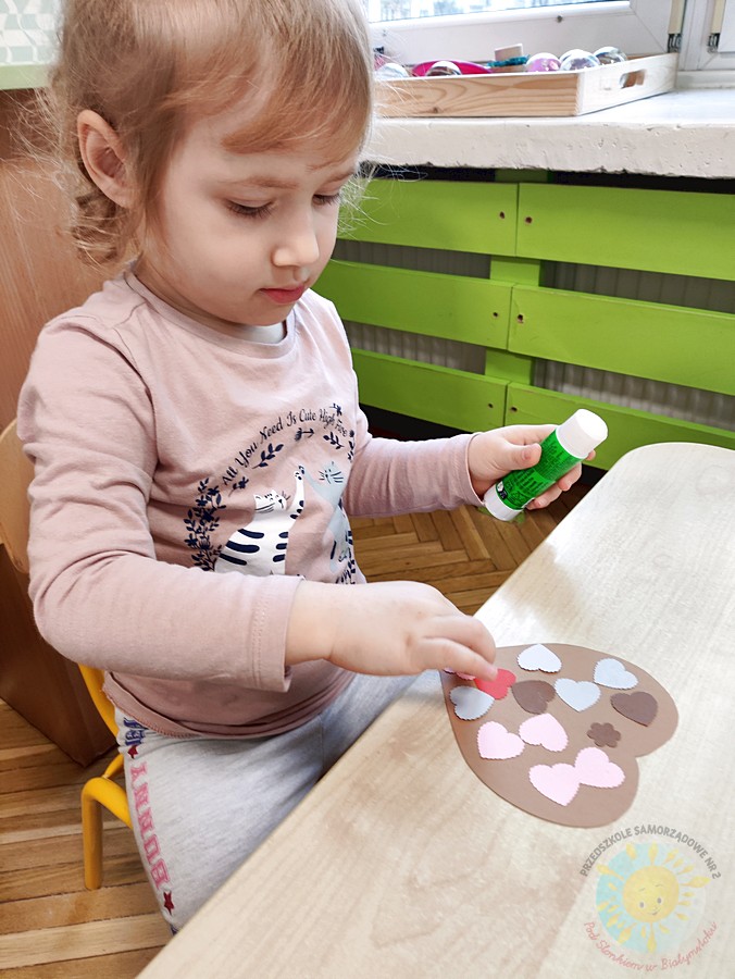 Siedzące dzieci przy stole i wykonują pracę plastyczną - Przedszkole Samorządowe Nr 2 Pod Słonkiem w Białymstoku