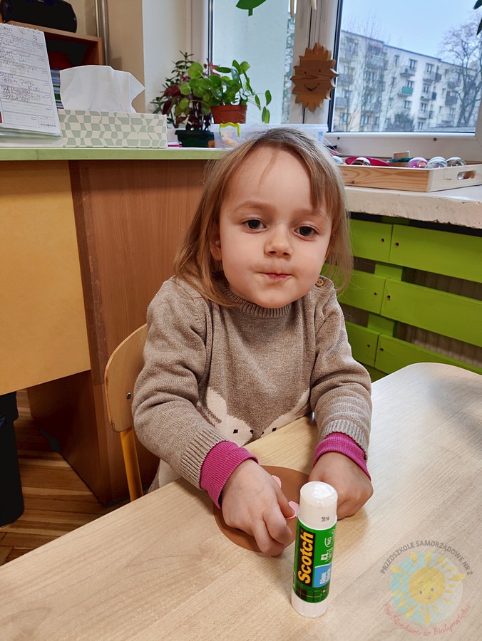 Siedzące dzieci przy stole i wykonują pracę plastyczną - Przedszkole Samorządowe Nr 2 Pod Słonkiem w Białymstoku