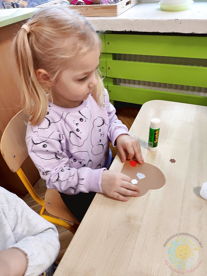 Siedzące dzieci przy stole i wykonują pracę plastyczną - Przedszkole Samorządowe Nr 2 Pod Słonkiem w Białymstoku