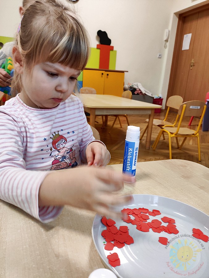 Siedzące dzieci przy stole i wykonują pracę plastyczną - Przedszkole Samorządowe Nr 2 Pod Słonkiem w Białymstoku