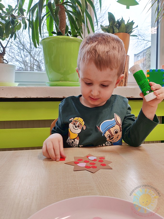 Siedzące dzieci przy stole i wykonują pracę plastyczną - Przedszkole Samorządowe Nr 2 Pod Słonkiem w Białymstoku