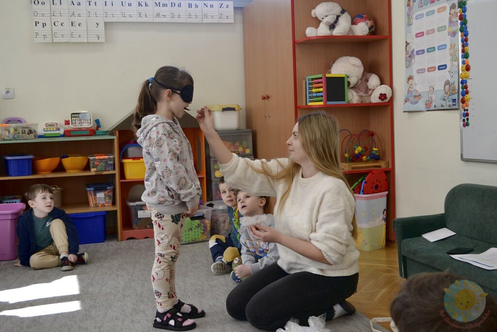 Siedzące dzieci na dywanie, które biorą udział w zajęciach - Przedszkole Samorządowe Nr 2 Pod Słonkiem w Białymstoku