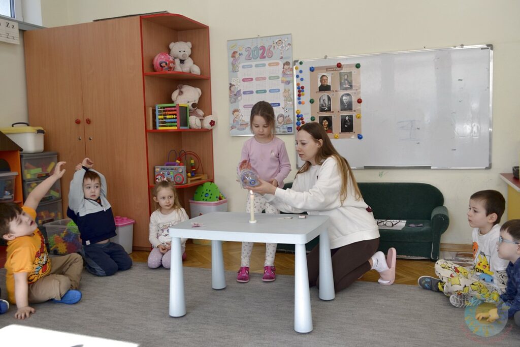 Siedzące dzieci na dywanie, które biorą udział w zajęciach - Przedszkole Samorządowe Nr 2 Pod Słonkiem w Białymstoku