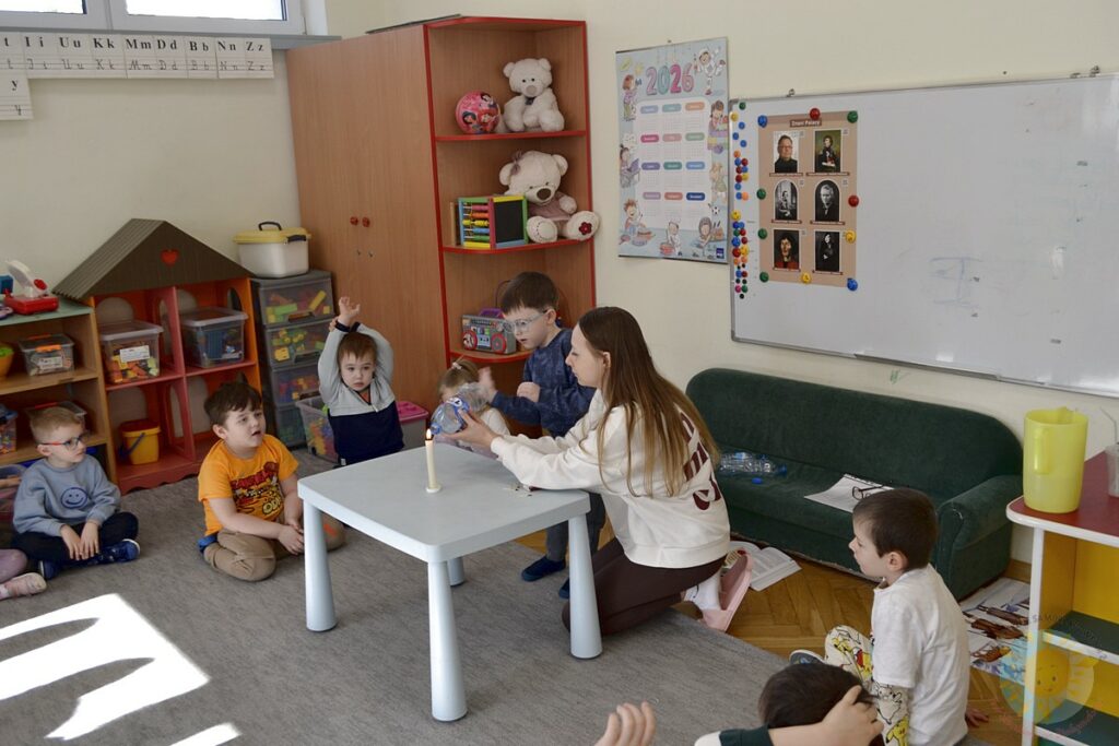 Siedzące dzieci na dywanie, które biorą udział w zajęciach - Przedszkole Samorządowe Nr 2 Pod Słonkiem w Białymstoku