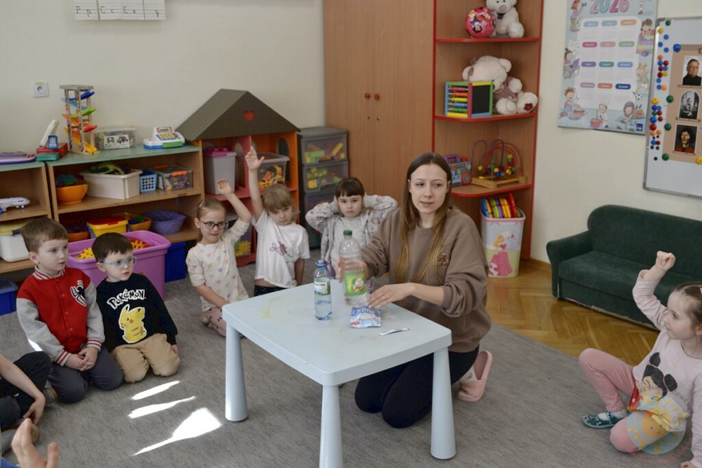 Siedzące dzieci na dywanie, które biorą udział w zajęciach - Przedszkole Samorządowe Nr 2 Pod Słonkiem w Białymstoku