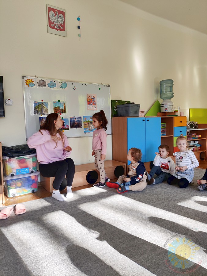 Stojące dziecko przy tablicy, wieszające obrazek - Przedszkole Samorządowe Nr 2 Pod Słonkiem w Białymstoku