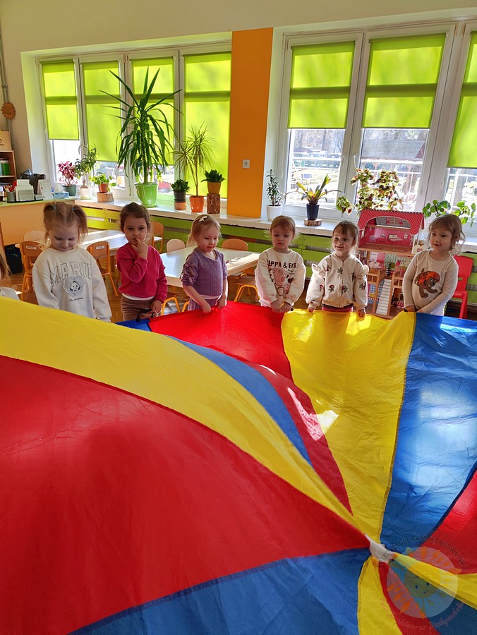 Bawiące się dzieci chustą KLANZA na dywanie przedszkolnym - Przedszkole Samorządowe Nr 2 Pod Słonkiem w Białymstoku