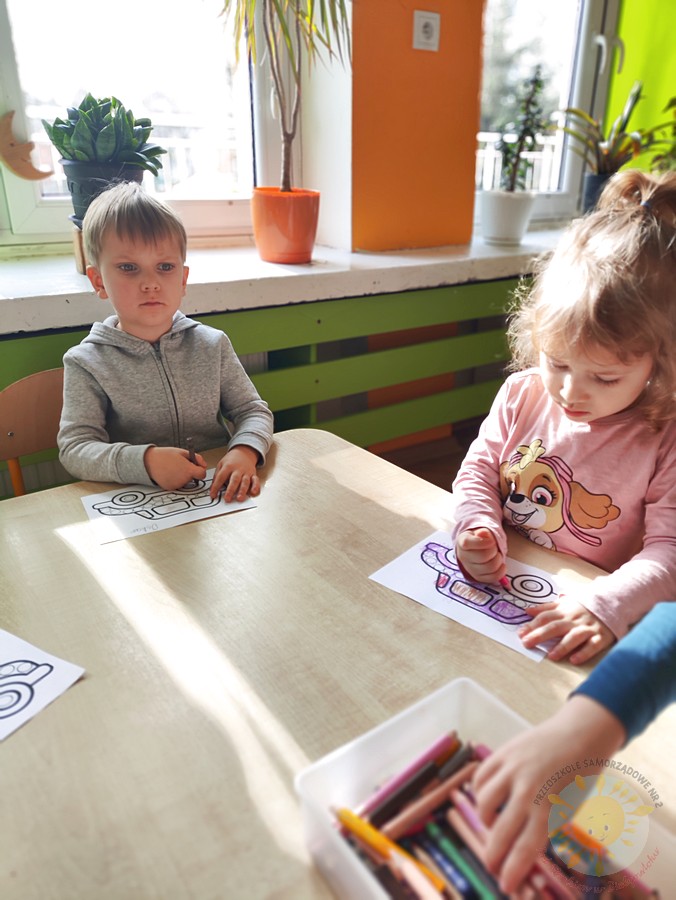 Siedzące dzieci przy przedszkolnym stoliku, wykonują pracę - Przedszkole Samorządowe Nr 2 Pod Słonkiem w Białymstoku
